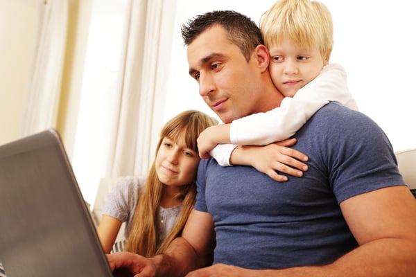 Father with children working on laptop computer at home-1